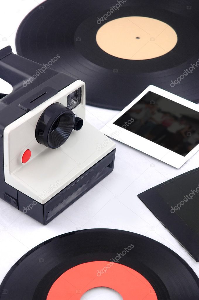 Old instant camera with vinyl and instant photos - eighties