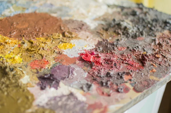 Corner of plank as painting palette with dry oil paint — Stock Photo, Image