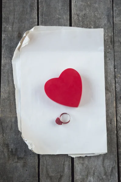 Bague et boîte cadeau sur papier et fond en bois gris — Photo