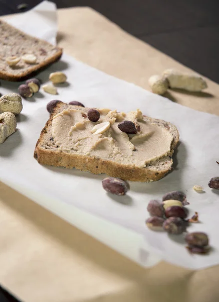 Pumpernickel bread with peanut butter and peanuts — Stock Photo, Image