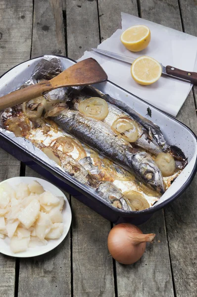 Mackerel fish in casserole with onion lemon and potato salad