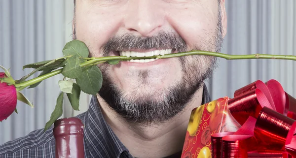 Imagen recortada del hombre sosteniendo vino presente y una rosa — Foto de Stock