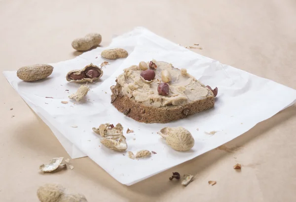 Peanuts and peanut butter on slice of bread — Stock Photo, Image