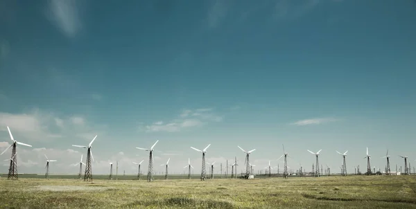 Row of towers with wind turbines in blue sky background