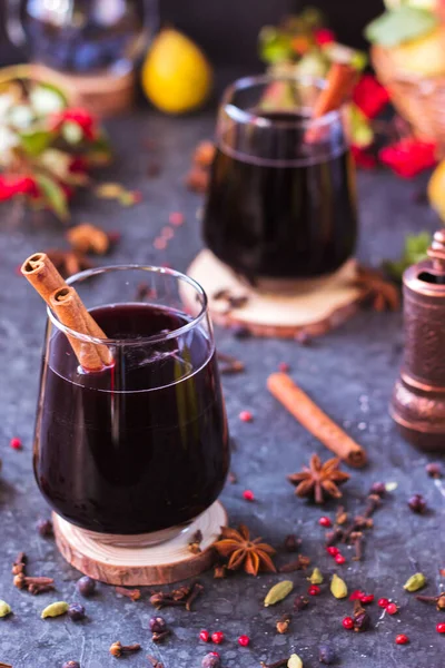 Hot wine with spices in glass glasses. Mulled wine with cinnamon and star anise on a table with fruit