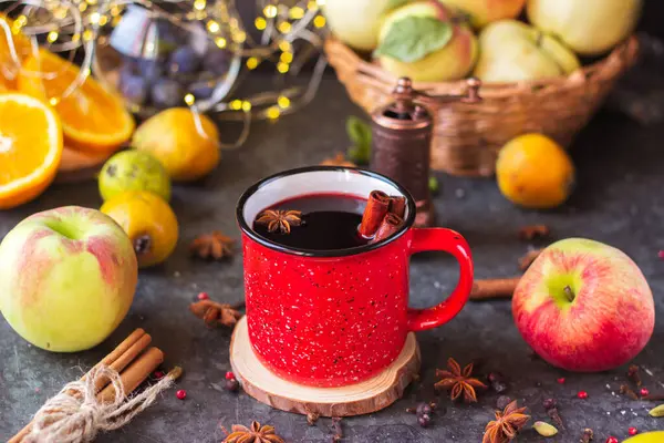 mulled wine in a red mug. hot spiced wine with cinnamon and star anise.