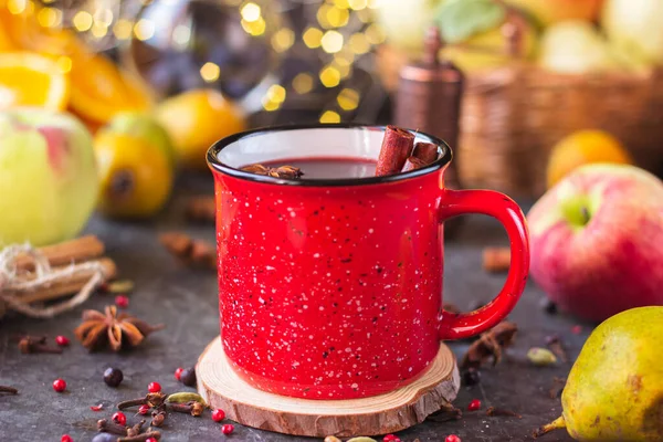 mulled wine in a red mug. hot spiced wine with cinnamon and star anise.