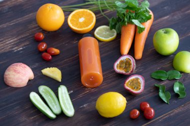 Kırsal ahşap arka planda çeşitli meyve ve sebze malzemelerinden yapılmış bir şişe soğuk sıkılmış sağlıklı meyve suyu. Detoks ve diyet yiyecek ve içecek konsepti.