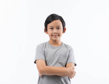 Asyalı şirin bir çocuğun portresi. Kollarını kavuşturup kendine güvenen pozlar veriyor..