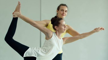 Bayan Yoga ustası, yeni öğrencinin vücut duruşuna ve hareketlerine alıştırma yapmasına yardımcı olur. Sağlık ve zihin derslerinde yeni beceriler öğrenme kavramı.