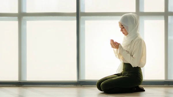 床に座って敬意と穏やかな方法で祈る若いと美しいアジアのイスラム教徒の女性 — ストック写真