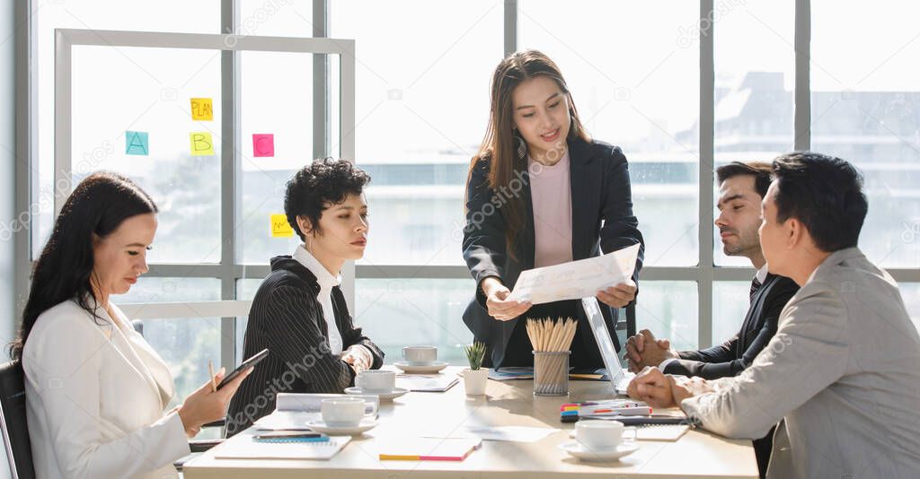 A Group of diverse businesspeople, Asan and Caucasian, make a conference together at the desk. Idea for good team at workplace.