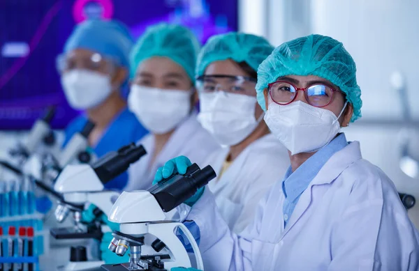Groep Vrouwelijke Onderzoekers Wetenschappers Met Beschermende Hygiënemaskers Medische Uniformen Die — Stockfoto