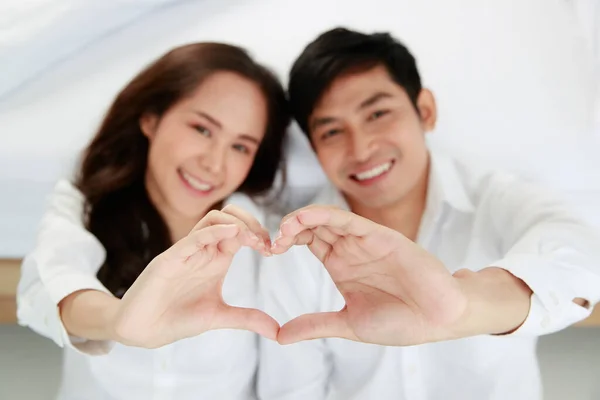 年轻而迷人的亚洲夫妻 身穿干净的白衬衫 坐在卧室的地板上 看着镜头手心的手势 爱情和幸福关系的概念 — 图库照片