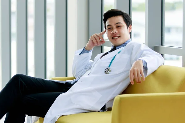 Asyalı Doktor Gülümseyen Yüzüyle Sandalyede Oturuyor — Stok fotoğraf