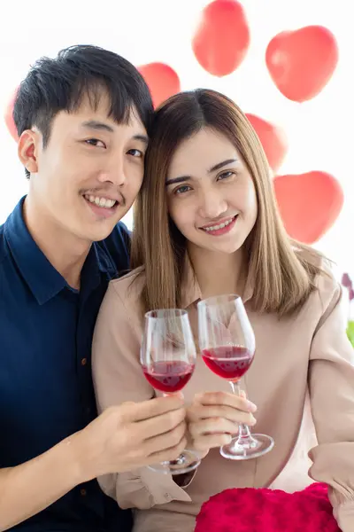 陽気なアジアの男性と女性は笑顔で ワインのグラスをクリックしながらカメラを見て 自宅で聖バレンタインデーのお祝い中にトーストを提案 — ストック写真