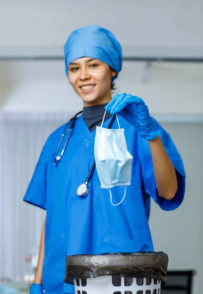 Ameliyat maskesinin portresi. Mutlu kadın özgürlük doktorundan dökülen portre fotoğrafı. Mavi hastane şapkalı, steteskoplu, gülümseyen bir kadın..