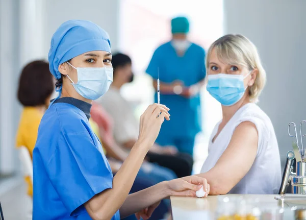 Ung Kvinnlig Professionell Läkare Bär Ansiktsmask Och Blå Sjukhusuniform Hålla — Stockfoto