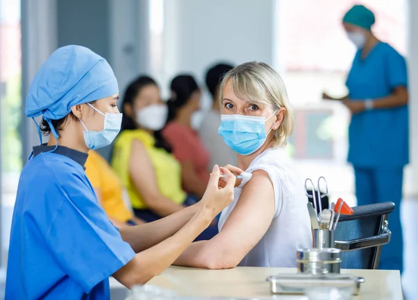 Kvinnlig Professionell Läkare Bär Ansiktsmask Och Blå Sjukhusuniform Injicera Koronovirus — Stockfoto