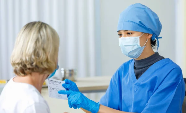 Ung Kvinnlig Läkare Blå Sjukhusuniform Ansikte Mask Och Gummihandskar Sitta — Stockfoto