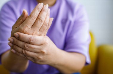 Bir kadın, acı, acı ve karıncalanma ile elini tutmak için elini kullanıyor. Guillain barre sendromu kavramı ve uyuşmuş eller hastalığı.