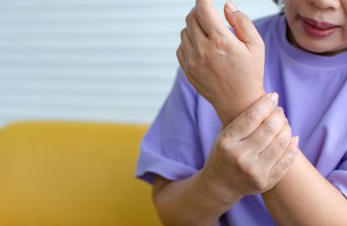 Bir kadın diğerini kollarında tutmak için elini kullanır ve acı hisseder, acı çeker, incinir ve sızlar. Guillain barre sendromu kavramı ve uyuşmuş eller hastalığı.