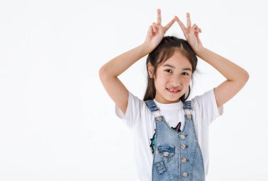 İzole edilmiş, kot etekli güzel bir kızın, el ele tutuşup kameraya baktığı, beyaz arka planda iki parmak barış işareti gösterdiği bir resim..