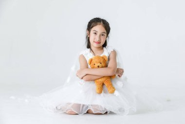 Asyalı güzel kızın izole edilmiş portresi. Beyaz prenses çiçekli elbise giyiyor. Moda kostümü giyiyor..