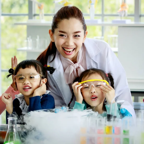 アジアの小学生の男の子と女の子のグループは 科学の科目の教育時間で学校の研究室で興奮し 煙反応を見て安全ゴーグルを着用します — ストック写真