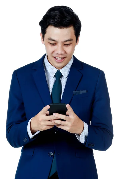 白いシャツを着た海軍ブルーのスーツを着た若い魅力的なアジアのビジネスマンと 白い背景に笑みを浮かべている携帯電話をチェックするネクタイ — ストック写真