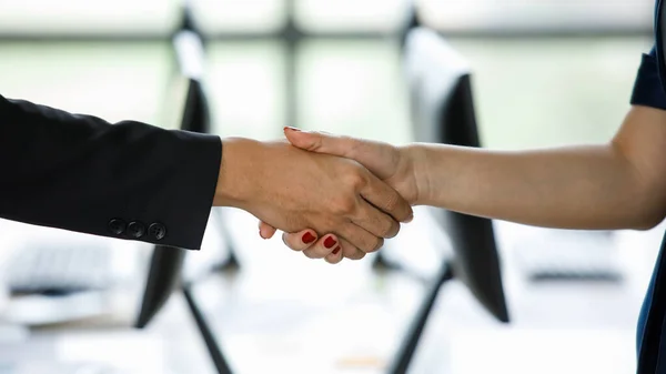 近代的なオフィスで2人のビジネスマンのクローズアップ握手 ビジネスマンとビジネスマンはコンピュータの背景で握手をする ビジネスパートナーの概念 ビジネスミーティング コラボレーション — ストック写真