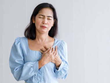 Ani kalp krizi geçiren ve göğsünü acılı bir şekilde tutan yetişkin bir kadın. Acil sağlık hizmeti kavramı ve konjestif yetmezlikten ya da kardiyopulmoner resüsitasyondan, kalp sorunundan etkilenme.