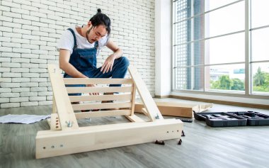 Tamirci olarak çalışan genç hippi, ahşap masayı malzemelerle birleştiriyor, ev yapımı ve self servis konsepti. Ofiste..