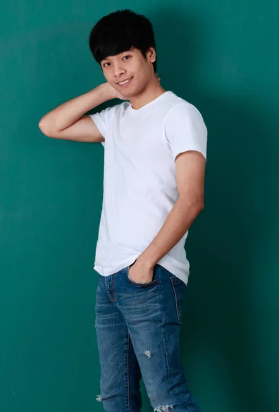 Zachwycony Młody Azjata Mężczyzna Białej Koszuli Dżinsy Stojące Zielonym Tle — Zdjęcie stockowe