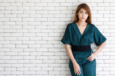 Uzun saçlı, genç ve şirin Asain kız portresi. Dostça ve kendinden emin bir tavırla poz veriyor..