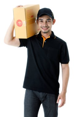 Dost canlısı Asyalı teslimatçı paketi sağ omzunda taşıyor. İzole edilmiş beyaz arka planda siyah üniformalı kurye portresi. E-ticaret iş konsepti