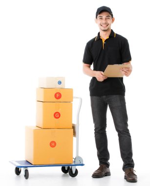 Neşeli Asyalı teslimatçı gülümsüyor ve teslimat kağıdını tramvayın yanında tutuyor. İzole edilmiş beyaz arka planda siyah üniformalı kurye portresi. E-ticaret iş konsepti