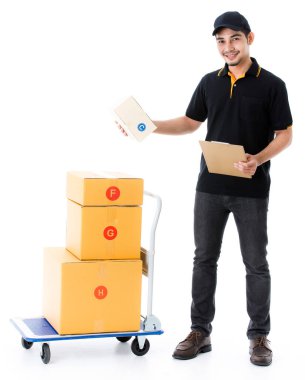 Neşeli Asyalı teslimatçı teslimat kağıdıyla paketleri kontrol ediyor. İzole edilmiş beyaz arka planda siyah üniformalı kurye portresi. E-ticaret iş konsepti