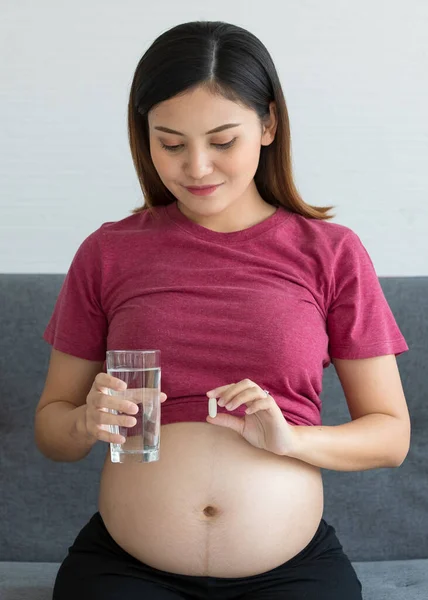 Feliz Smiley Joven Embarazada Asiática Sentada Sofá Sosteniendo Vaso Agua — Foto de Stock