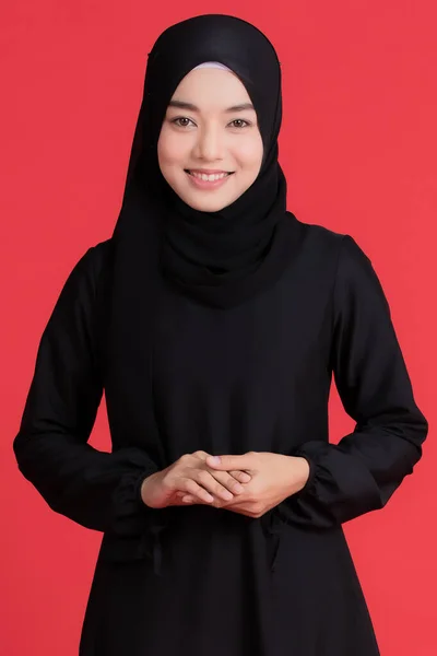 黒いヒジャーブを身に着けている美しいイスラム教徒のアジアの女性 立ちポーズと赤の背景に陽気に笑みを浮かべて 宗教儀式の概念では — ストック写真