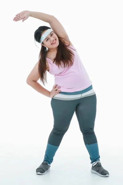 亚洲身材健康 体形魁梧 体形魁梧 身穿运动服 头戴发球带 微笑着伸展胳膊 在白种人面前锻炼的女孩的画像 — 图库照片