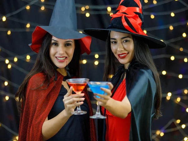 Веселые Молодые Женщины Костюмах Ведьм Звонят Стаканы Красочными Коктейлями Веселясь — стоковое фото