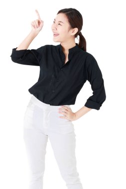 Asyalı iş kadını, günlük siyah gömlek giyen mutlu bir şekilde gülümseyen, reklam için işaret eden ve sunan, izole beyaz arka plan kesimli boş fotokopi alanına bakan,