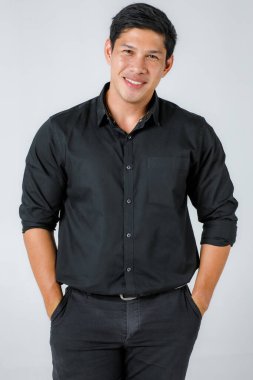 Siyah, şık, sıradan kostümlü Asyalı adamlar. Genç ve sağlıklı görünüyor. Kendinden emin, beyaz arka planda izole edilmiş bir portre çekimi..