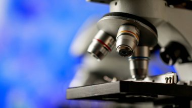 Mikrobiyoloji laboratuvarında fiziksel madde araştırmaları ve hücre araştırmaları için kullanılan çeşitli büyütme veya gözlem ölçekleri için seçici mercek hedefleriyle mikroskobun yakın çekimi