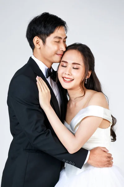 若い魅力的なアジアのカップルは すぐに花嫁と新郎 女性の白い結婚式のガウンを着ている 黒いタキシードを着た男が抱き合っていた 結婚式前の写真のコンセプト — ストック写真