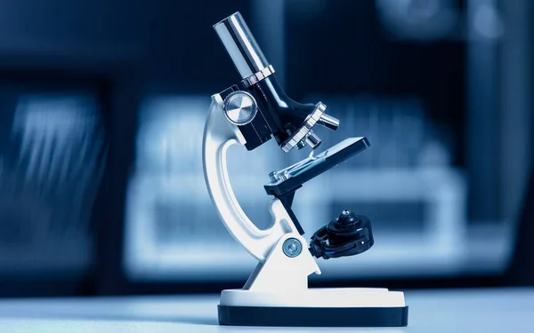 一方の目の顕微鏡の行の科学的な顕微鏡のショットを閉じます研究室の作業台の前にぼやけた線コロナウイルスCovid 19ウイルスサンプルを監視するために使用 — ストック写真