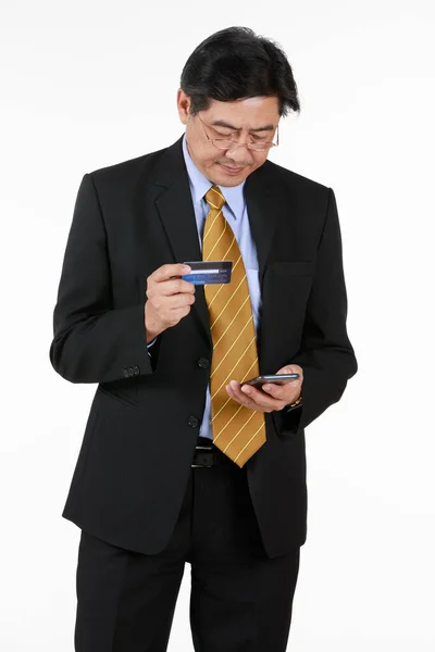 Senior Man Står Kollar Betalning Sitt Kreditkort Mobiltelefon Verkar Som — Stockfoto