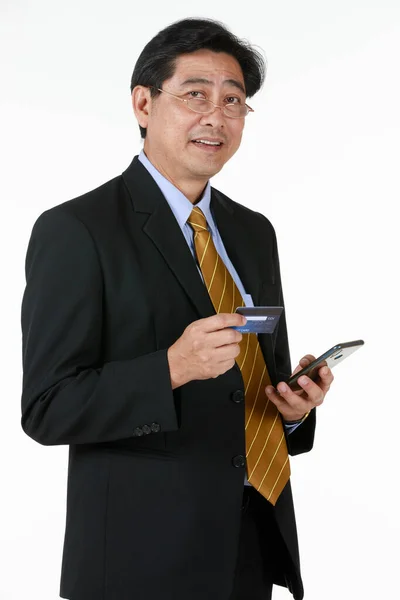 Starszy Mężczyzna Stojący Sprawdzający Swoją Kartę Kredytową Przez Telefon Komórkowy — Zdjęcie stockowe