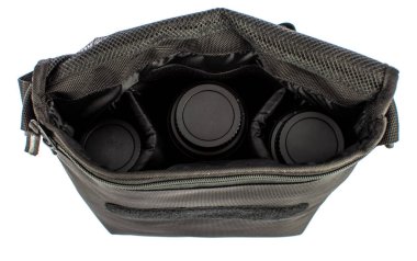 Ayrı bir yakın çekim stüdyo çekimi. Yeni, günlük, çalışan fotoğraf makinesi, çapraz vücut çantası, kompartıman cepleri ve fotoğrafçı için cırt cırtlı kayış, beyaz arka plan önünde üç lens..